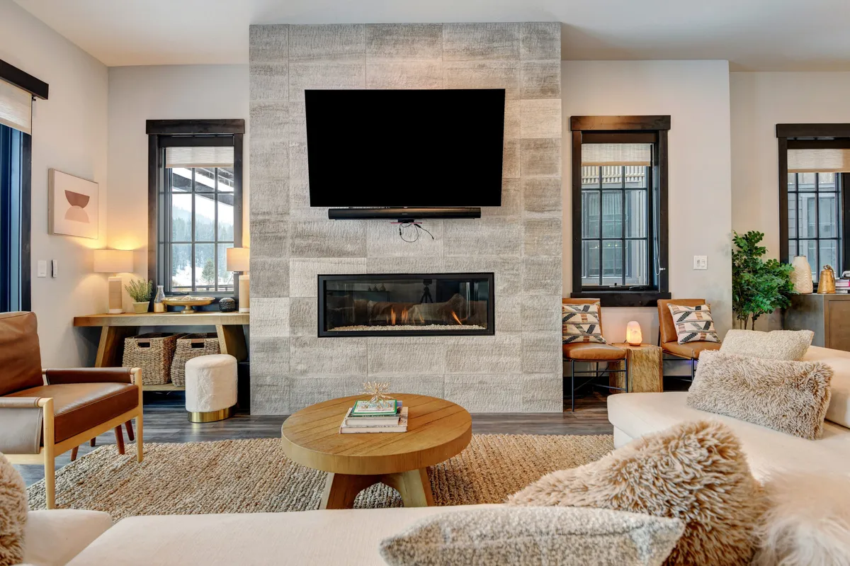 A welcoming living area with a sofa, coffee table, fireplace, television, and artwork. The layout is perfect for relaxing, watching TV, socializing, or hosting game nights, encapsulating the spirit of entertainment and downtime.